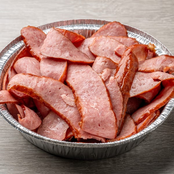 Sliced smoked sausage in a foil container from Hawg Jaw Que & Brew.